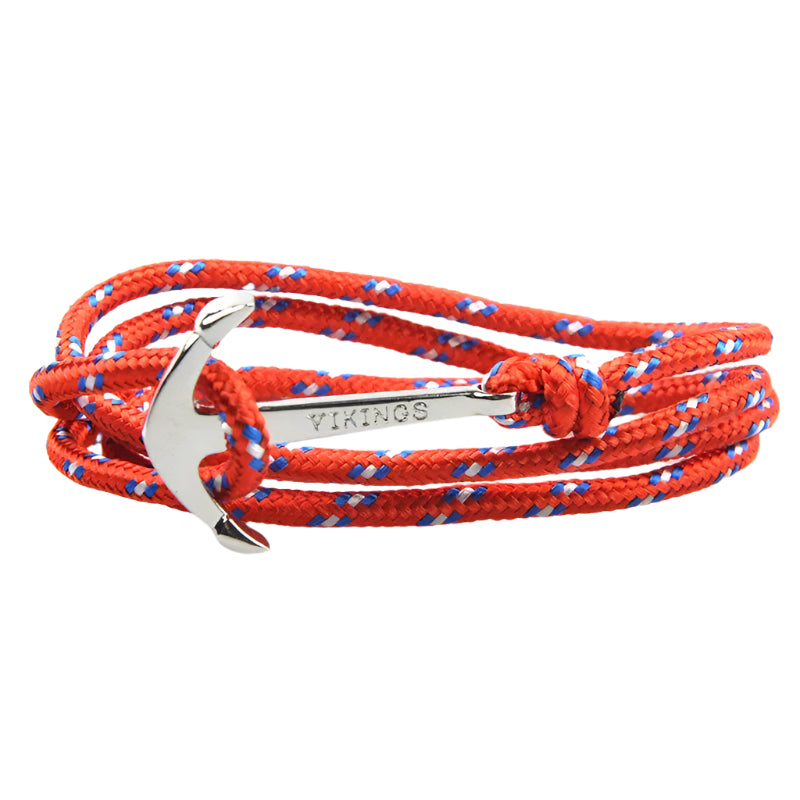 Red and blue braided rope bracelet with silver anchor charm on a white background.